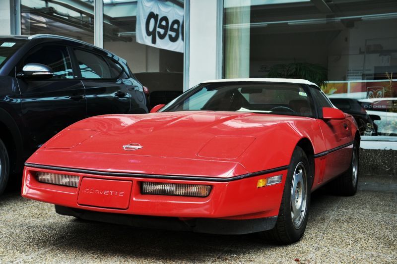 Rote Corvette vor dem Autohaus Oppitzhauser von vorne und Fahrerseite aus betrachtet